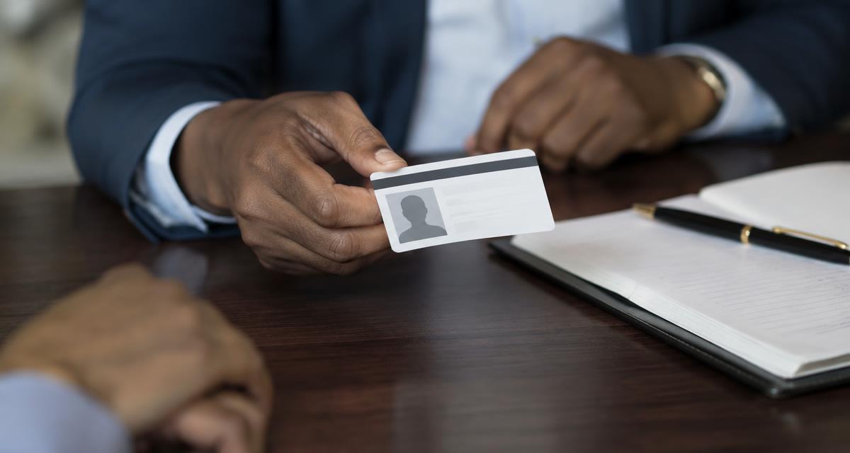 A driver's license and passport laid on a table next to a document ready for notarization